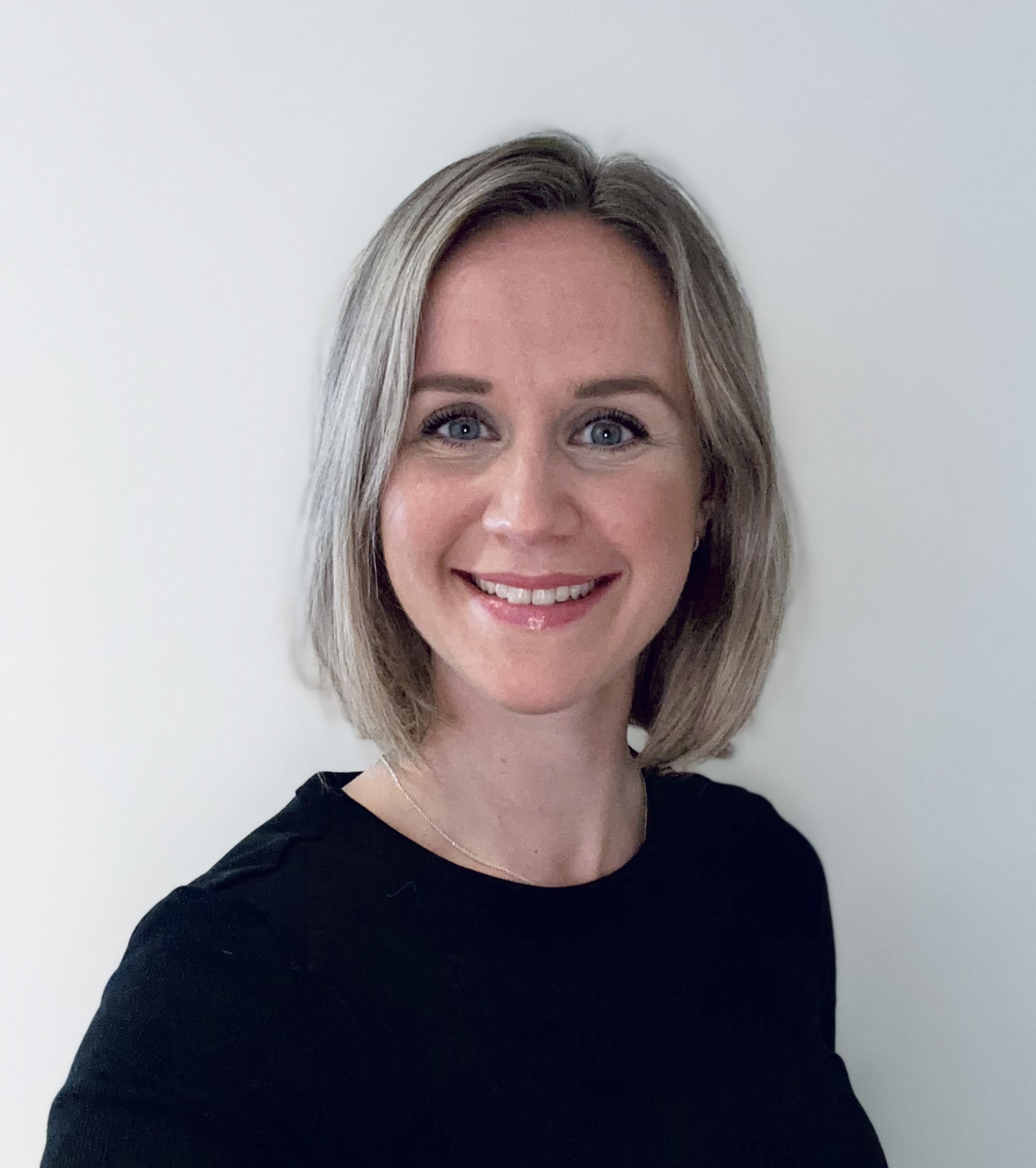 En kvinne som smiler til kameraet
