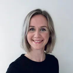 En kvinne som smiler til kameraet