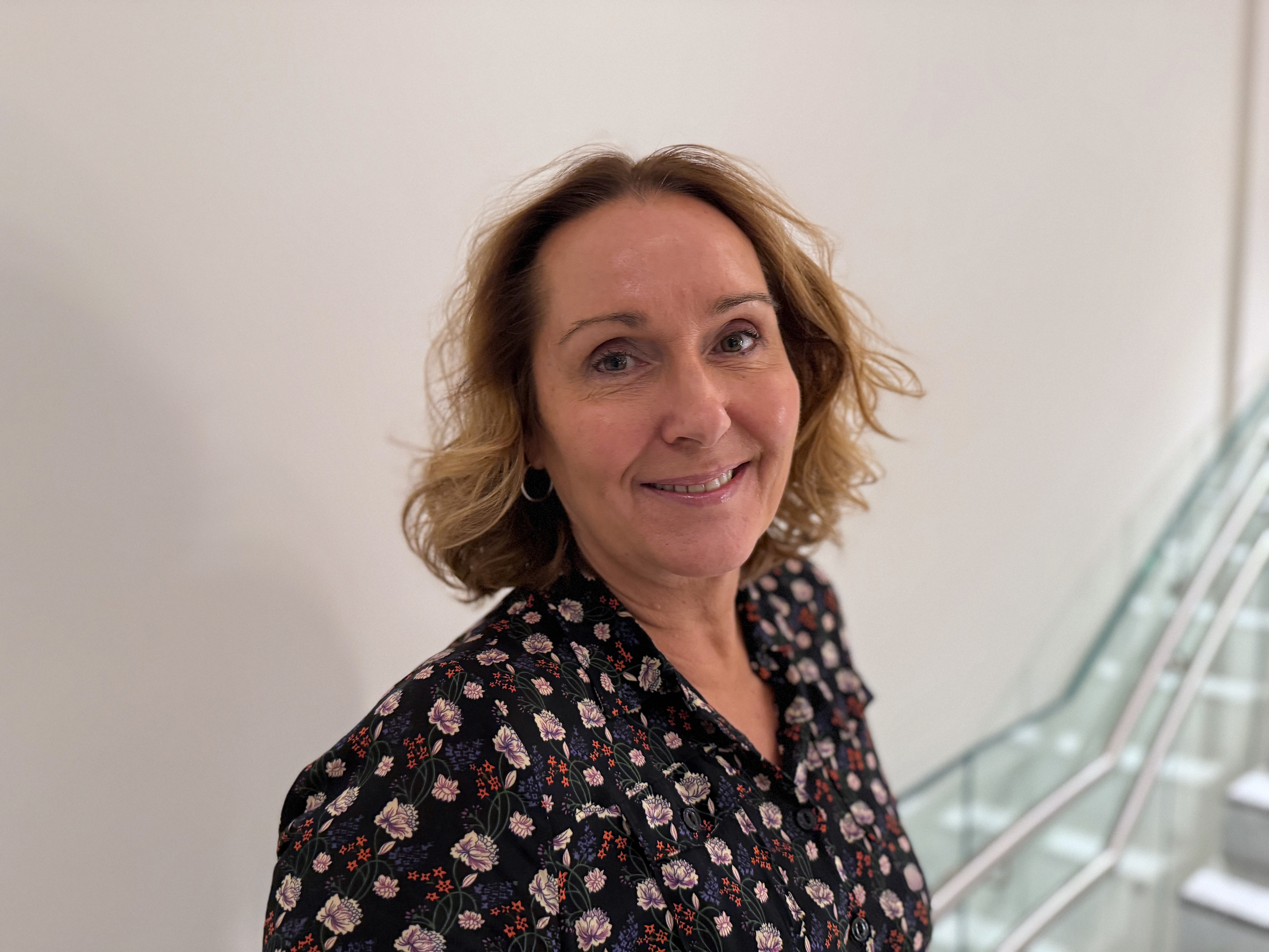 En kvinne som smiler til kameraet