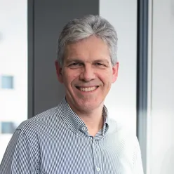 En mann som smiler til kameraet