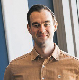 En mann som smiler til kameraet