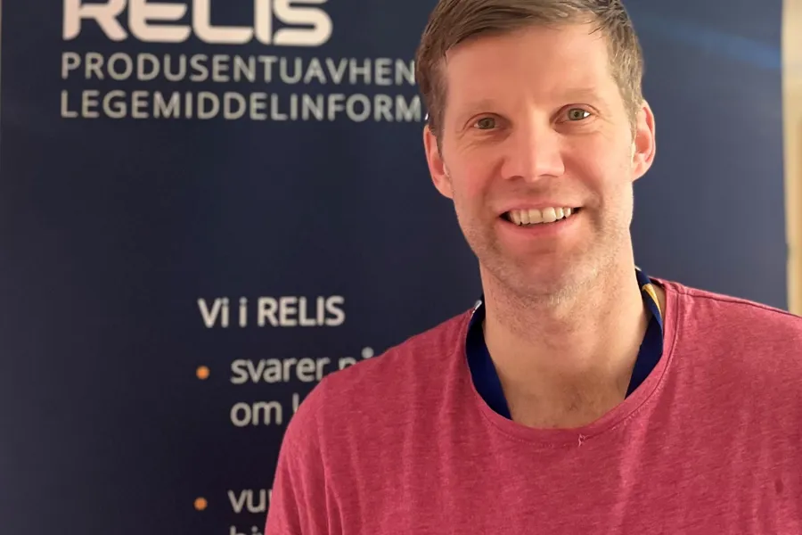 En mann som smiler til kameraet