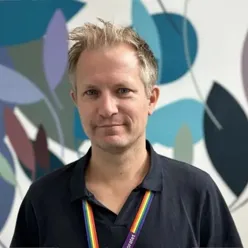 En mann som smiler til kamera