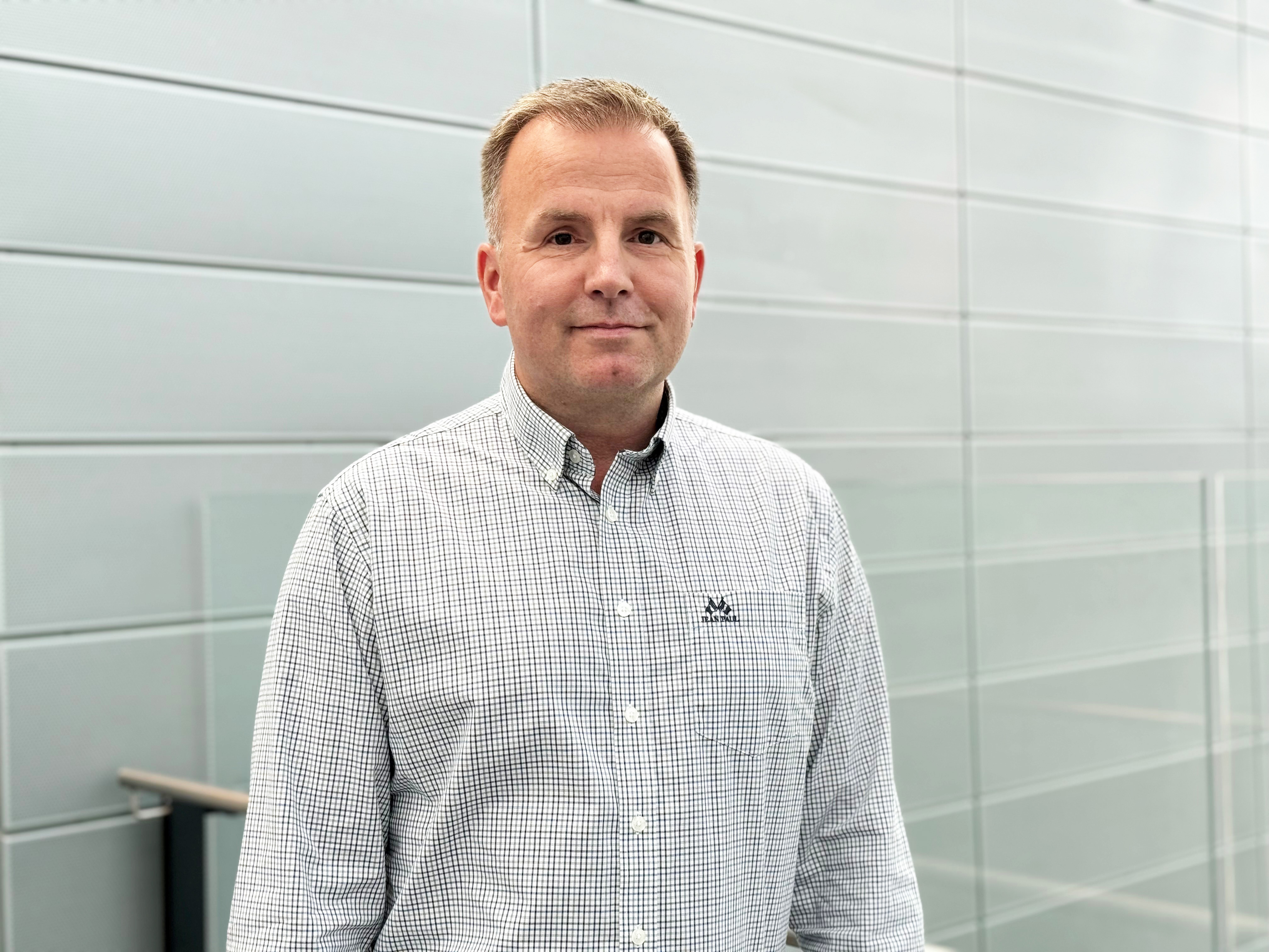 En mann som står foran en flisvegg