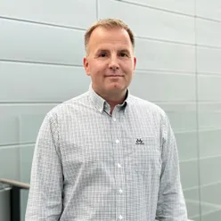 En mann som står foran en flisvegg