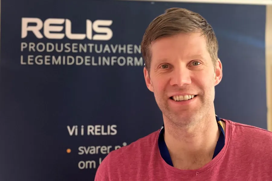 En mann som smiler til kameraet