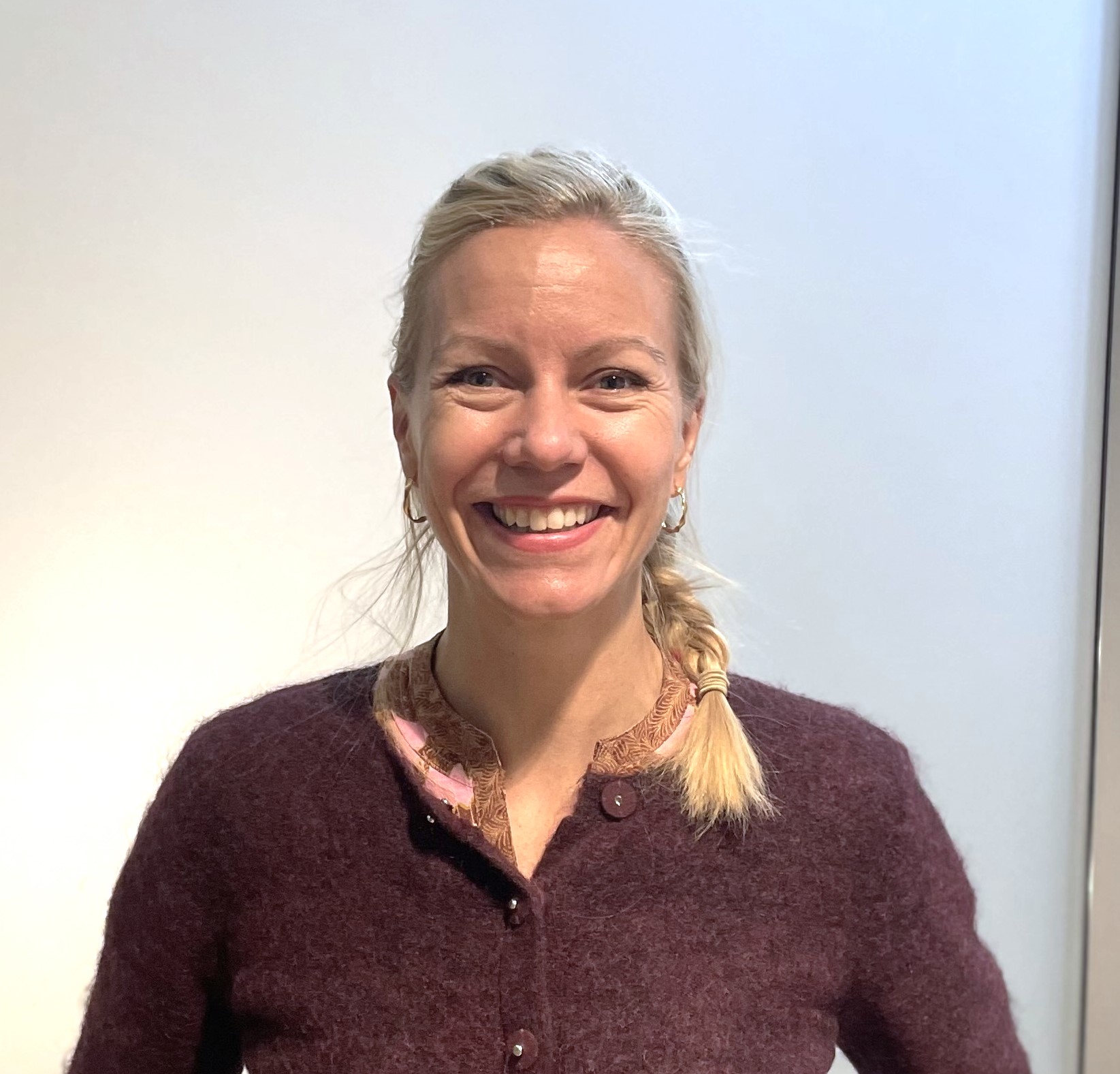 En kvinne som smiler til kameraet