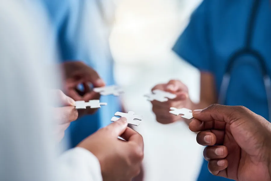 Nærbilde av folk som holder puslespillbrikker