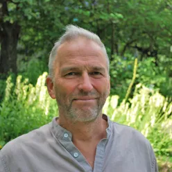 En mann som står foran trær