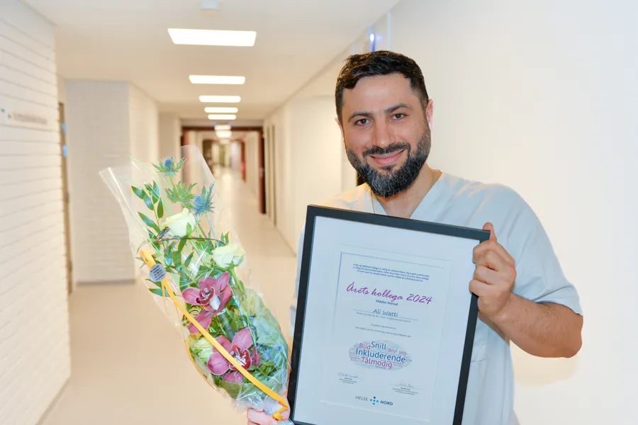 Mannlig lege med diplom og blomster