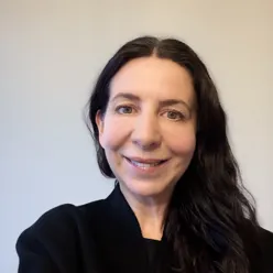 En kvinne som smiler til kameraet