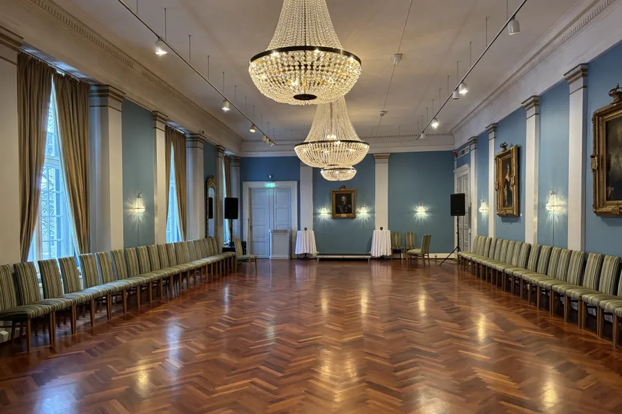 En stor hall med lysekrone og stoler