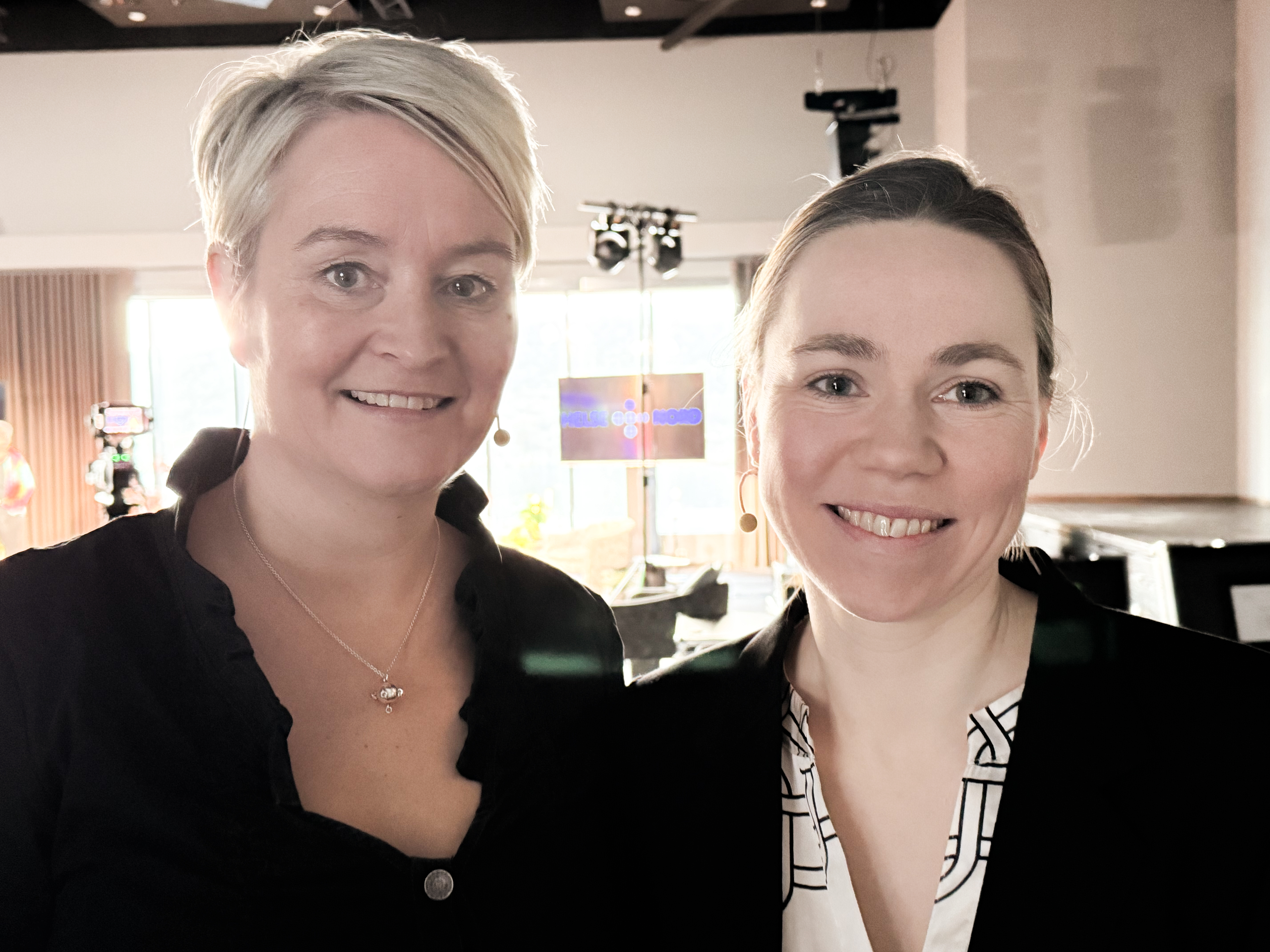 To kvinner som ser i kamera og smiler