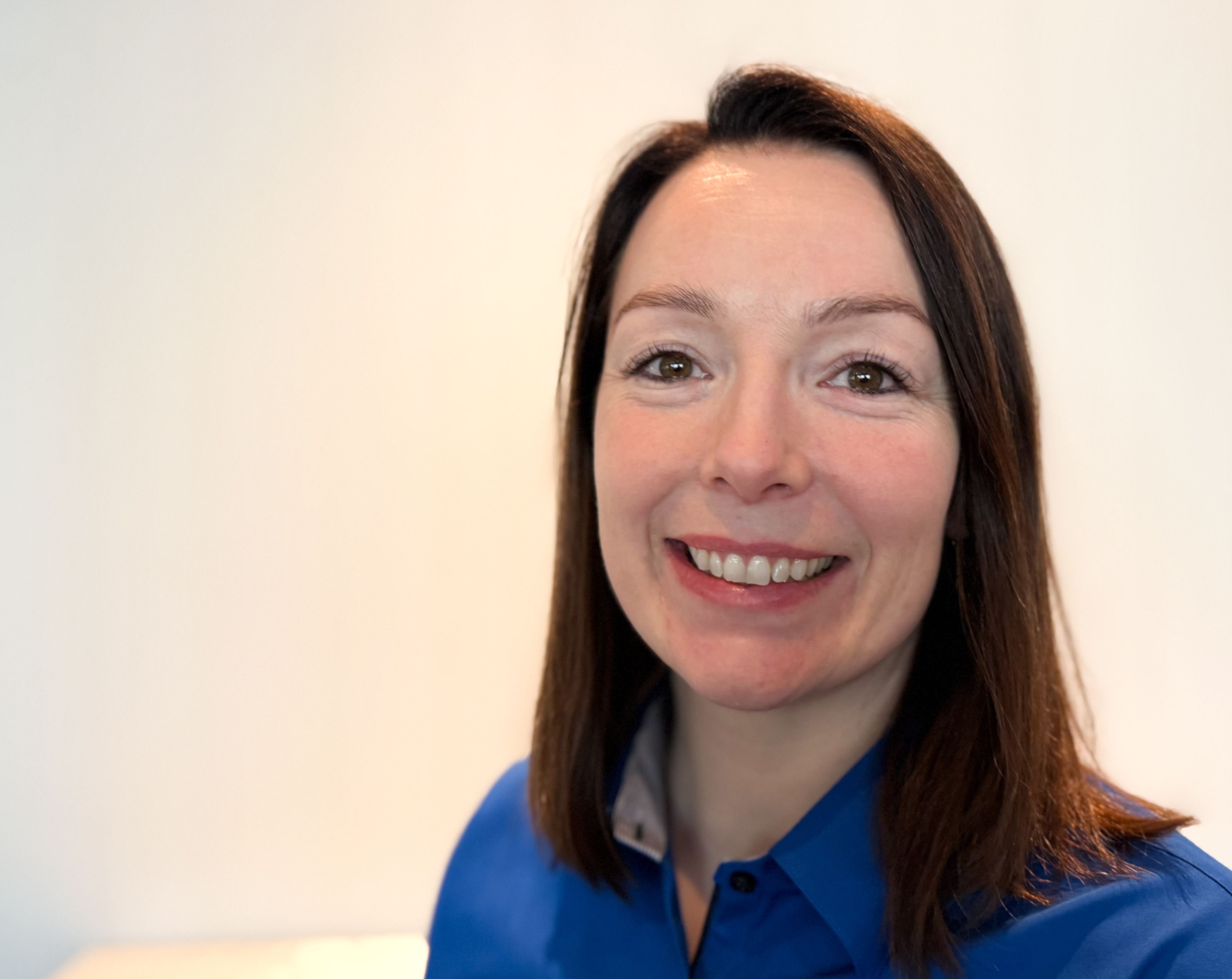 En kvinne som smiler til kameraet