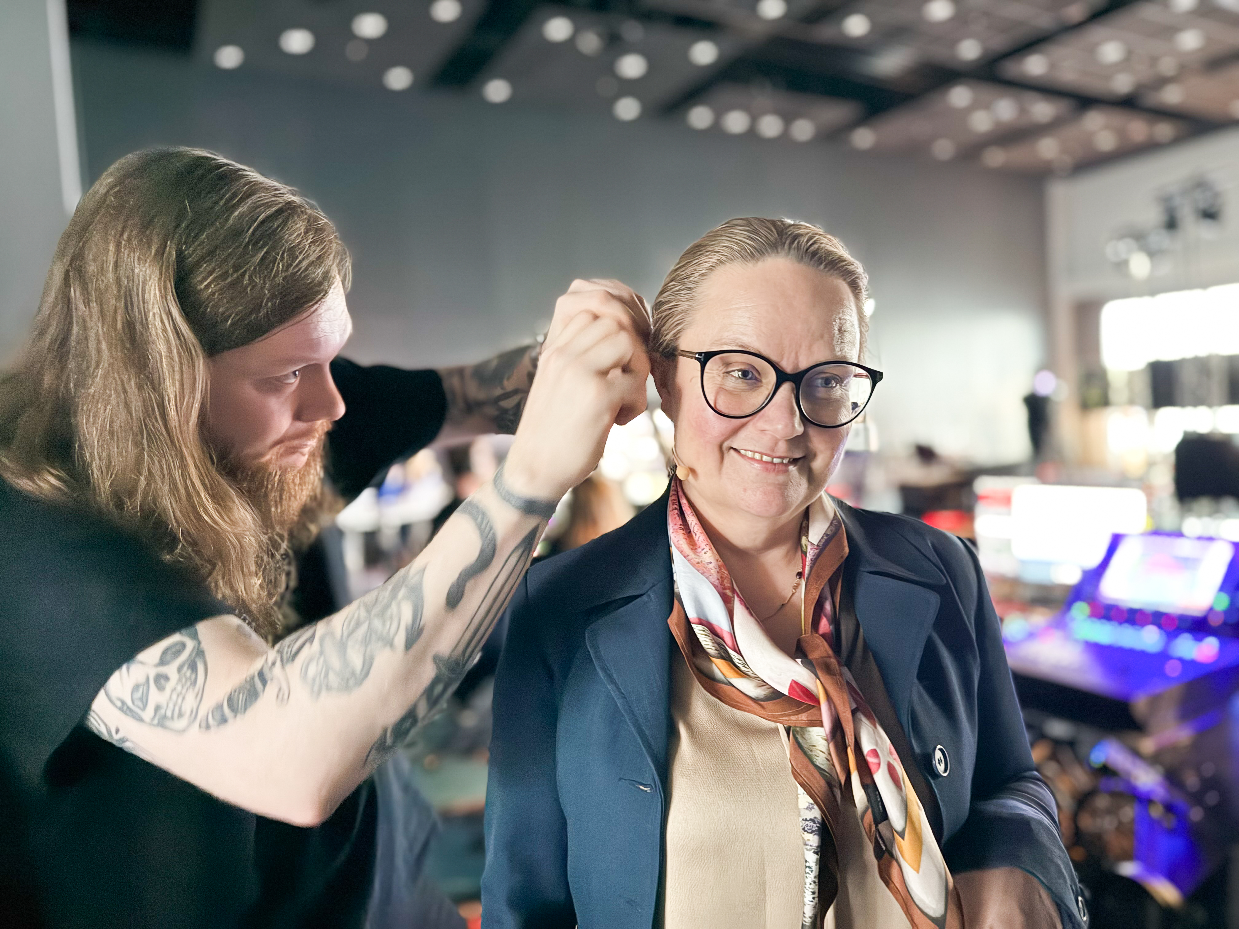 Tekniker plasserer en lydbøyle på en kvinne