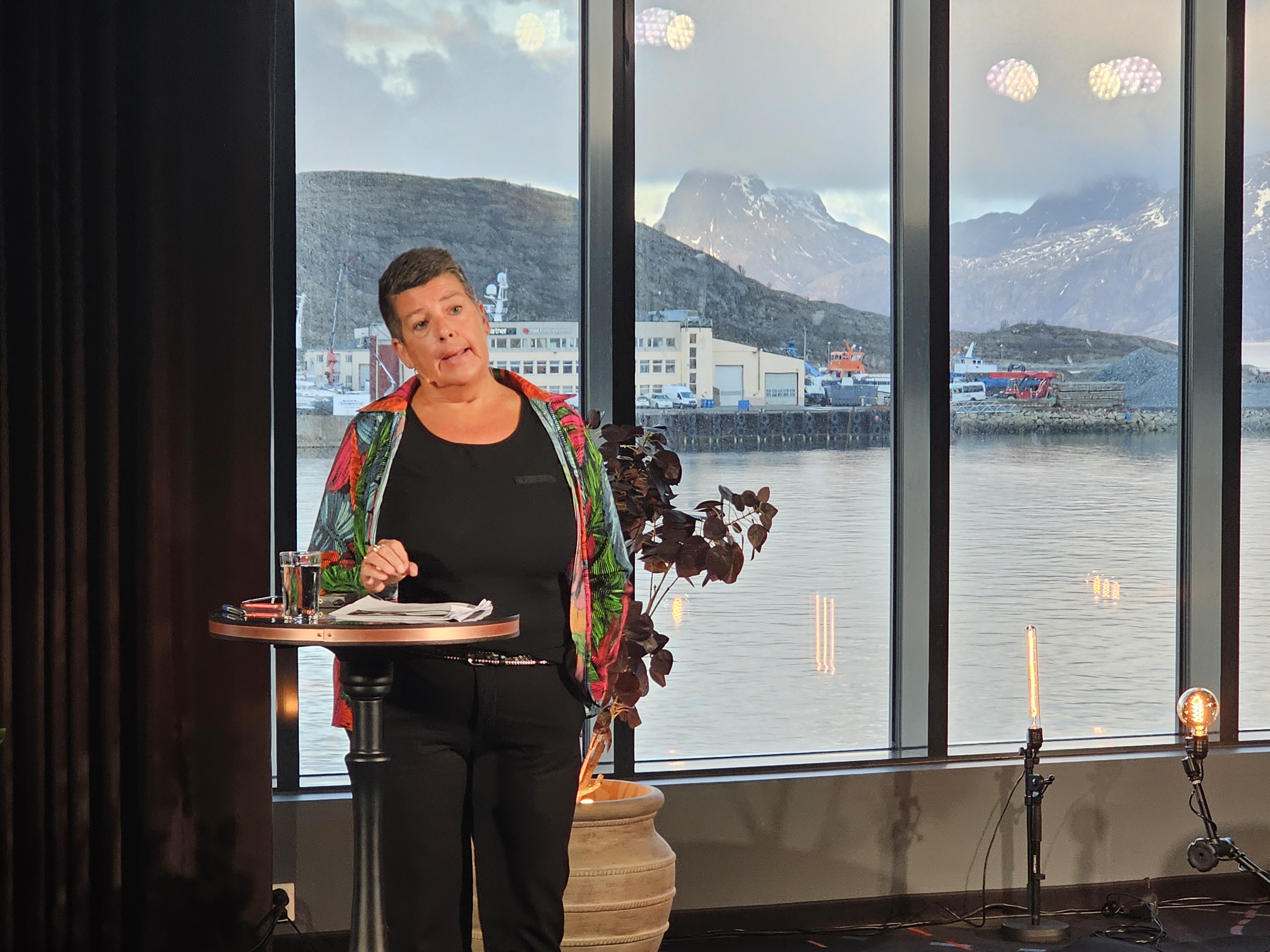 En person som står ved et vindu med utsikt over en by og fjell