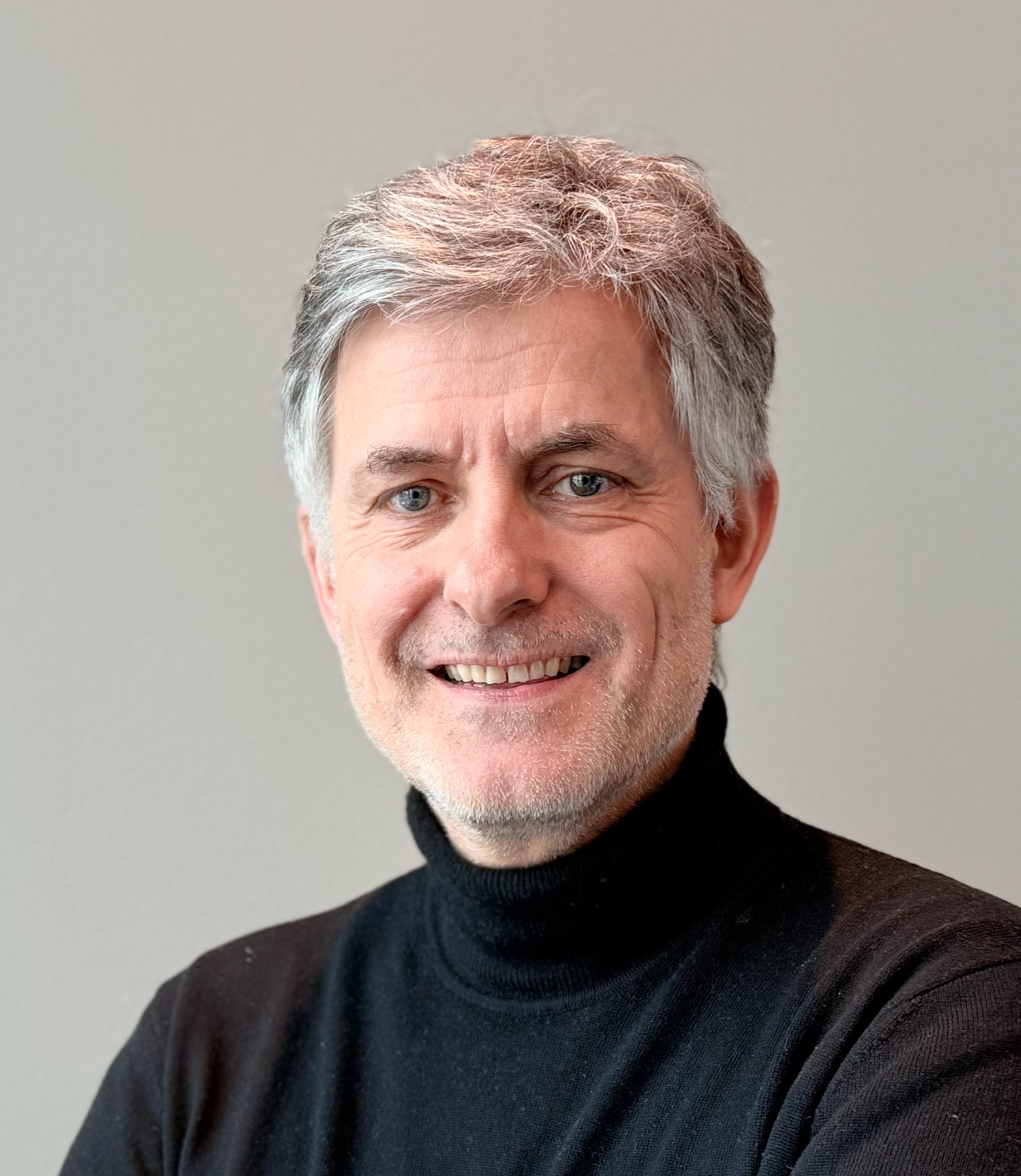 En mann som smiler til kameraet