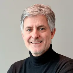 En mann som smiler til kameraet