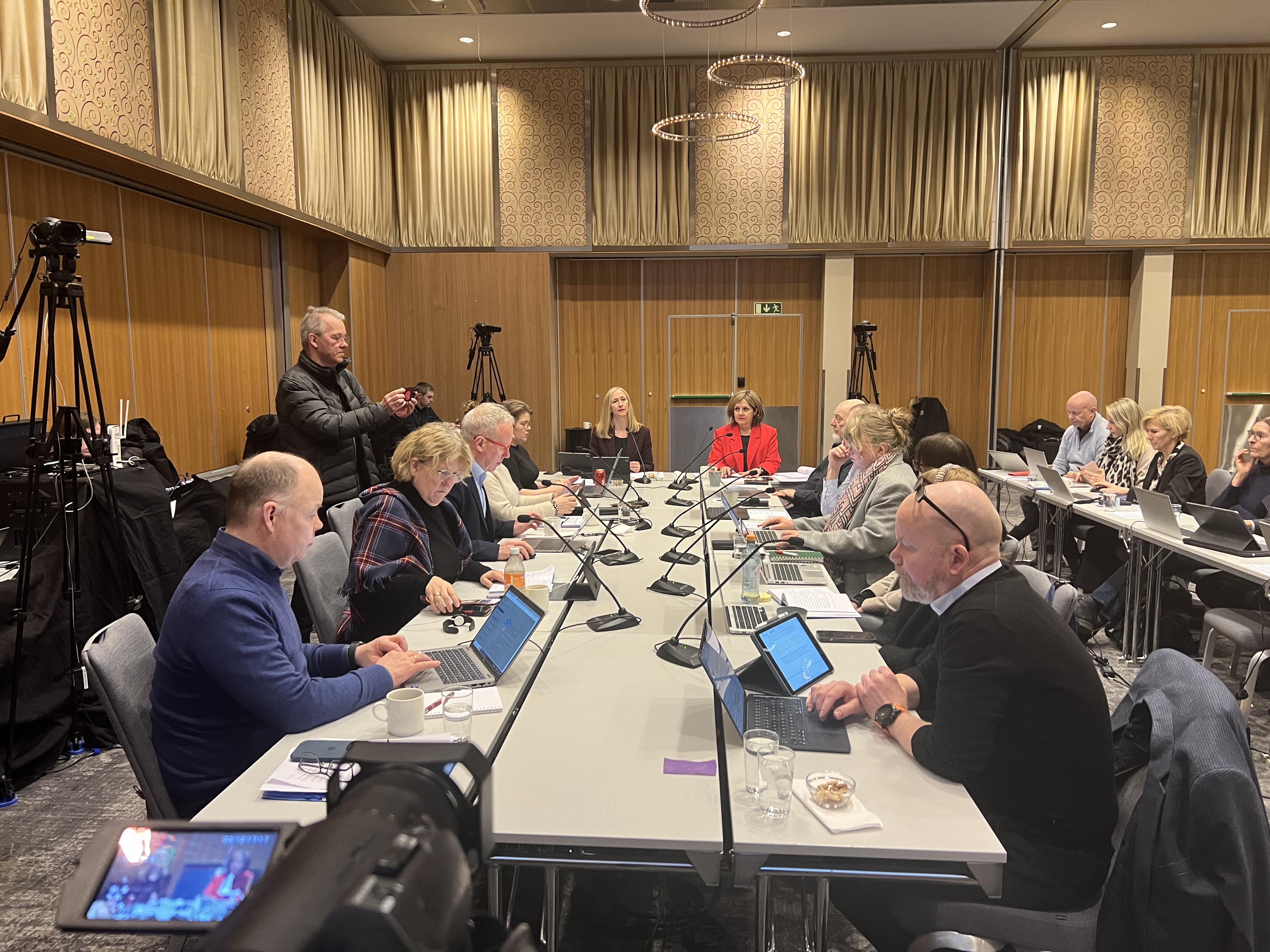 En gruppe mennesker som sitter ved et bord med bærbare datamaskiner