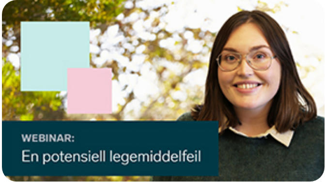 En kvinne som smiler med et skilt bak seg