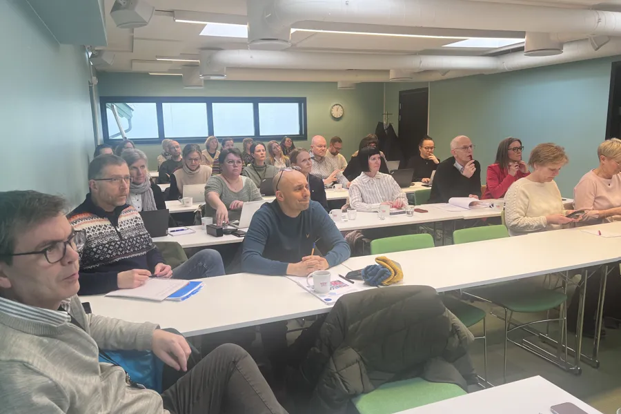 En gruppe mennesker som sitter ved bordene