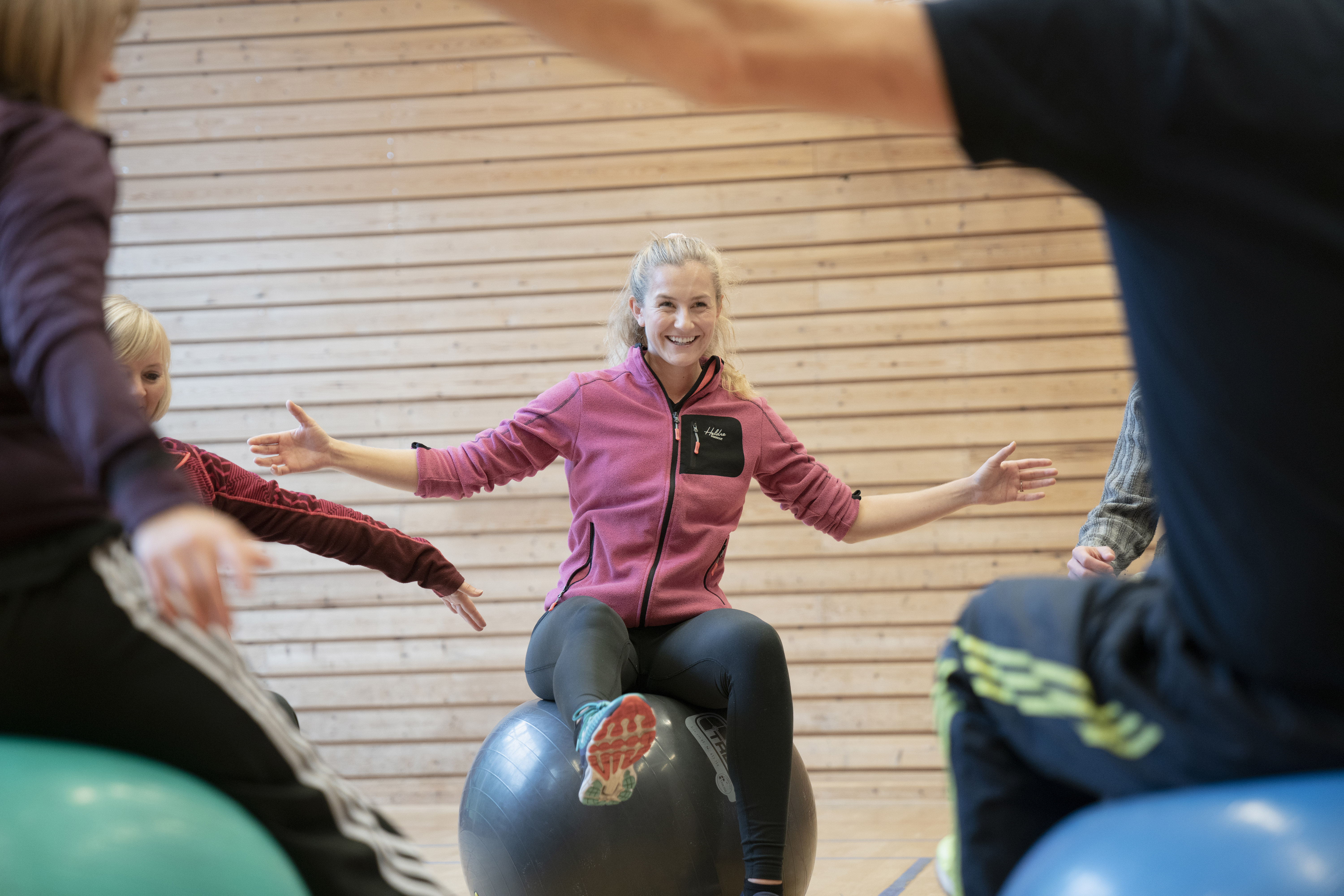 Mennesker i en gymsal på gymballer.