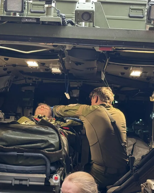 En gruppe mennesker i et rom med en stor maskin