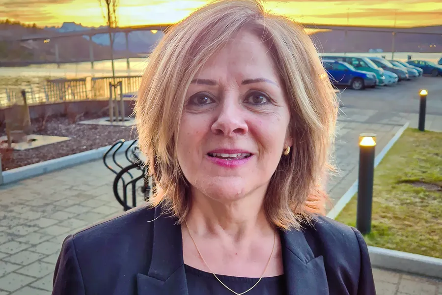 En kvinne som smiler til kameraet