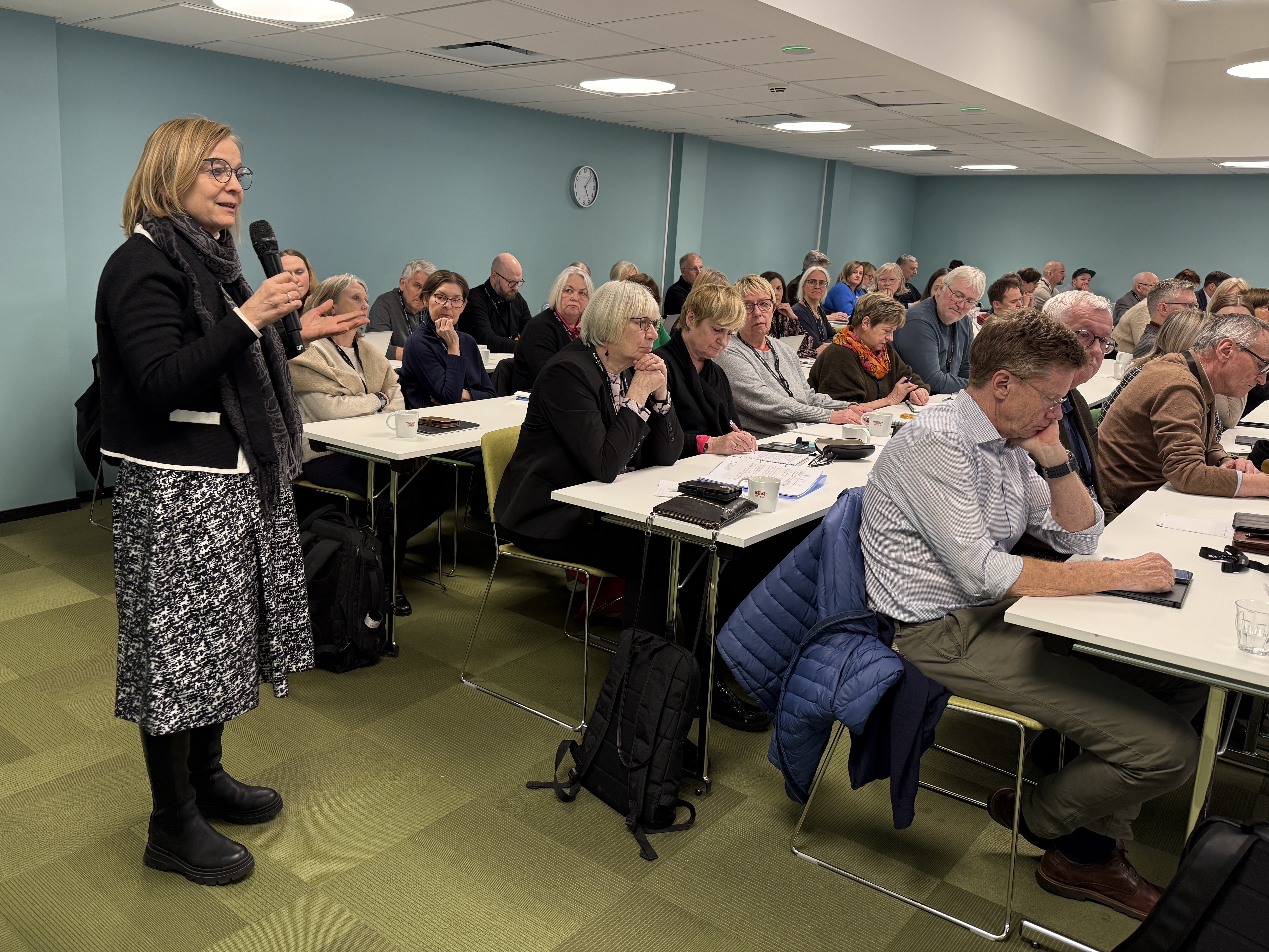 En gruppe mennesker som sitter ved bord