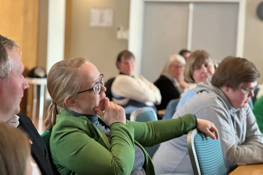 En gruppe mennesker som sitter i et rom