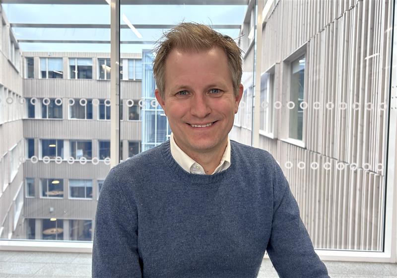 En mann som smiler til kameraet