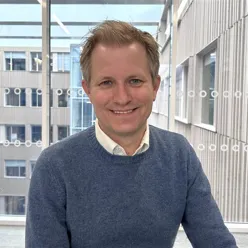 En mann som smiler til kameraet