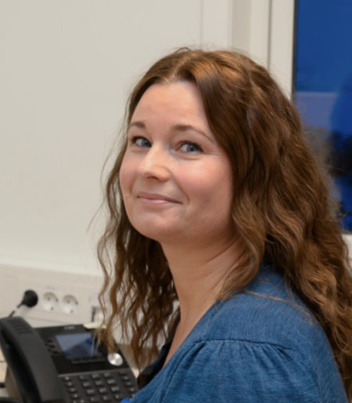 En kvinne som smiler til kameraet