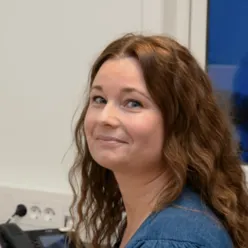 En kvinne som smiler til kameraet