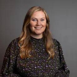 En kvinne med langt hår som smiler