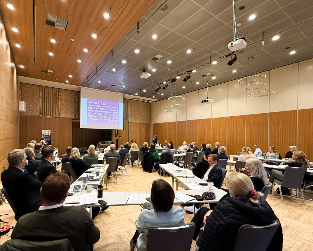 En gruppe mennesker som sitter i et konferanserom