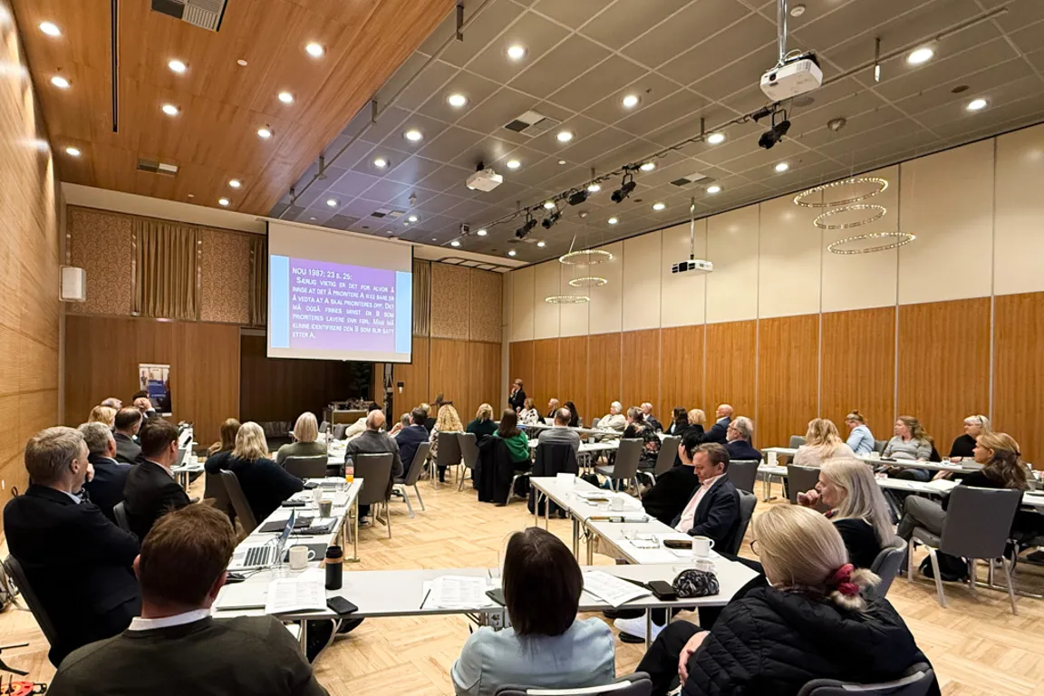 En gruppe mennesker som sitter i et konferanserom