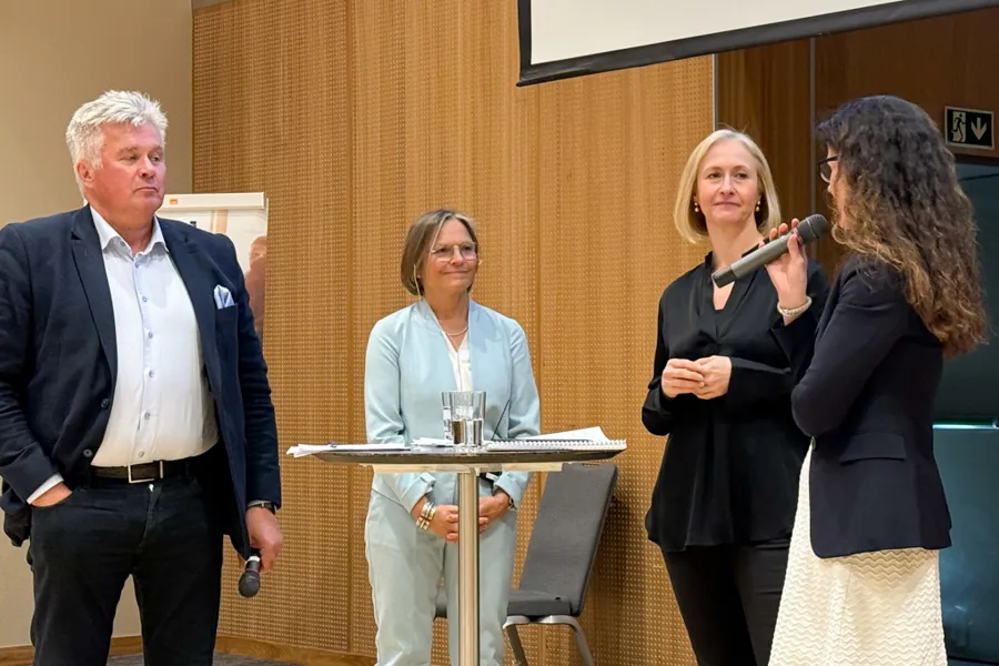 En gruppe mennesker som står foran et podium