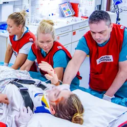 En gruppe mennesker som ser på en baby i en sykehusseng