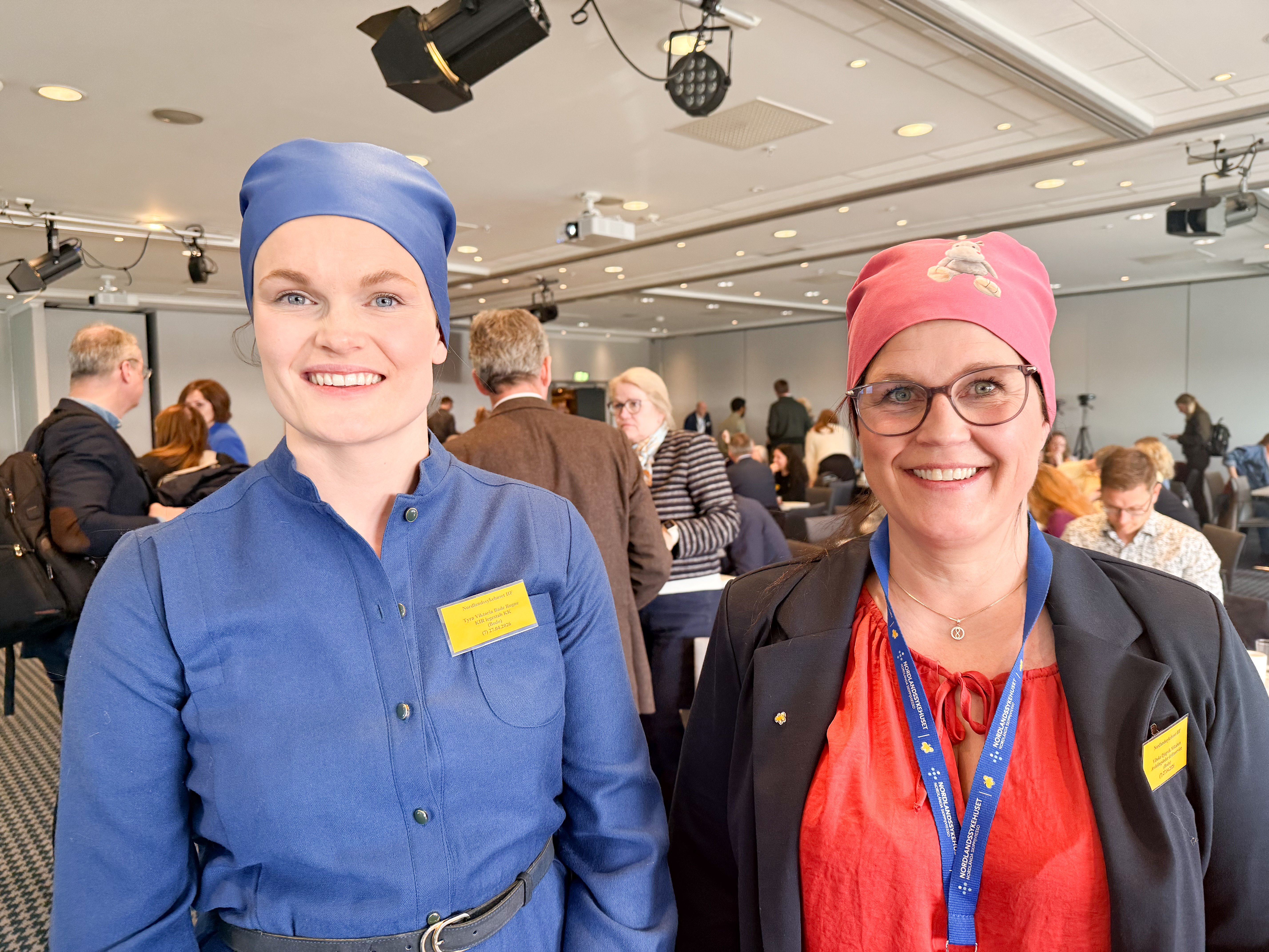To kvinner med tøyhetter i blå og rød