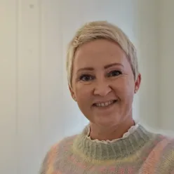 En kvinne som smiler til kameraet