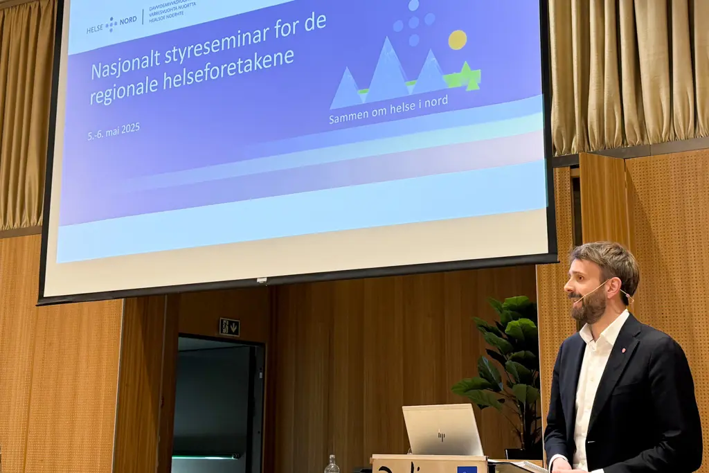 En mann som står foran et projektorlerret