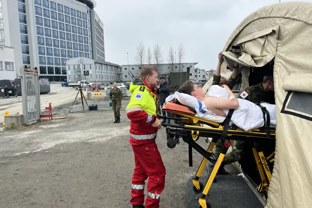 Pasient bæres inn i feltsykehuset