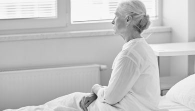 En person som sitter på en seng