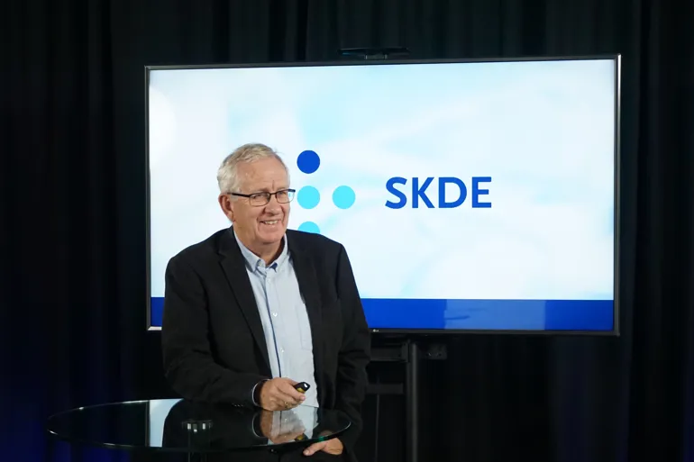 En mann som står foran en skjerm