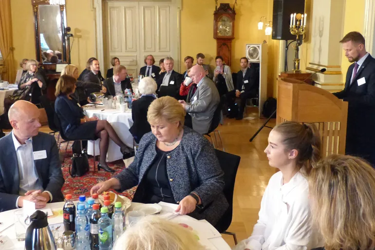 En gruppe mennesker som sitter ved bordene