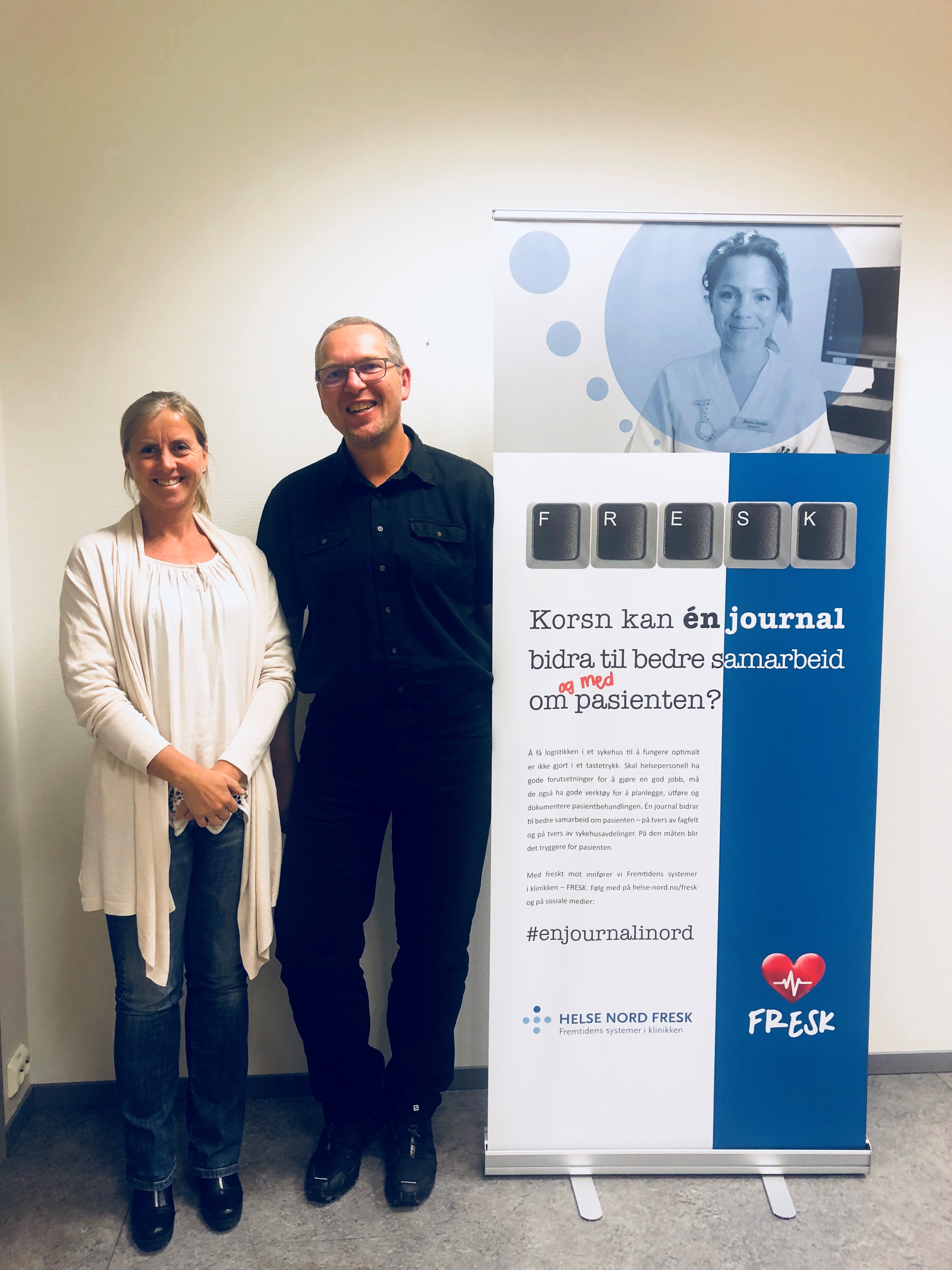 En mann og en kvinne som står ved siden av en plakat