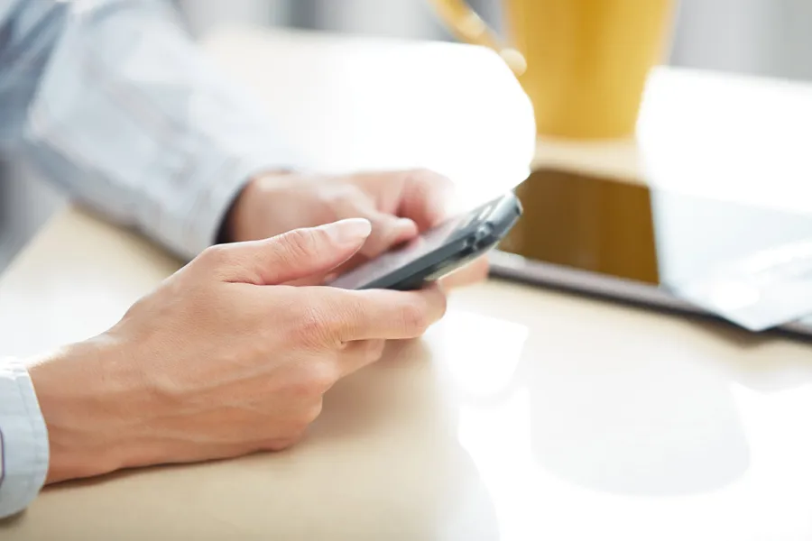 Hender holder mobiltelefon