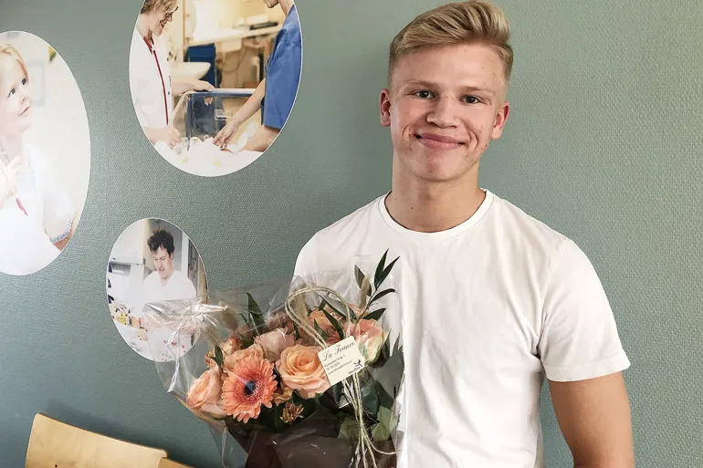 En mann som holder en blomsterbukett