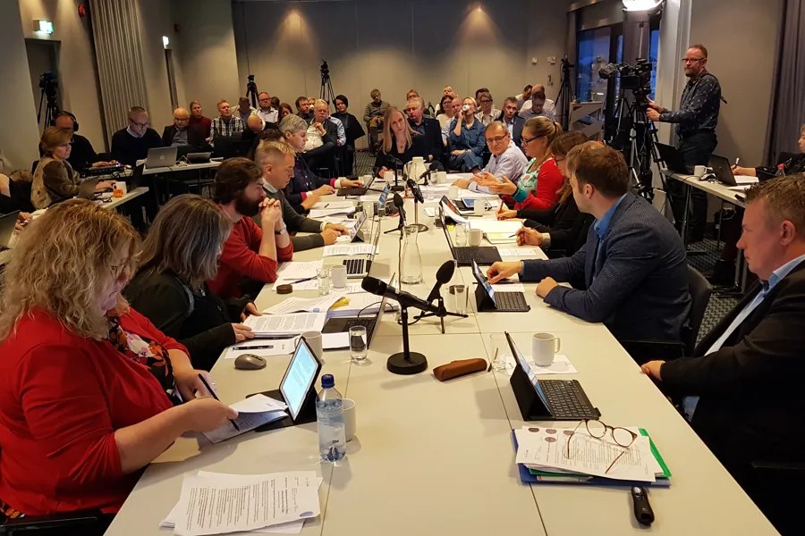 En gruppe mennesker som sitter rundt et bord med bærbare datamaskiner